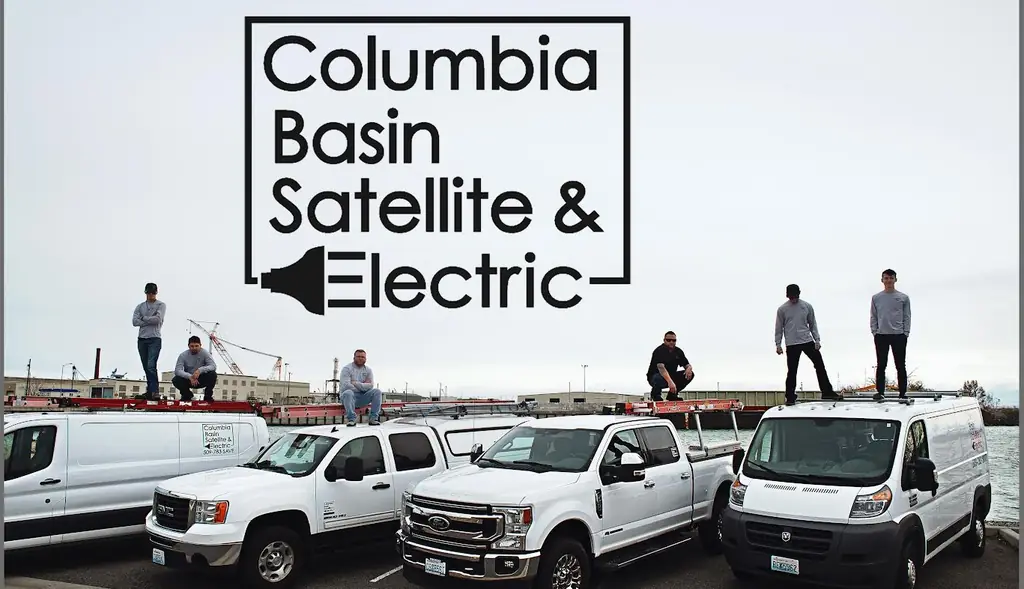 Six crew members posed on the roofs of four white fleet vehicles at a waterfront lot
