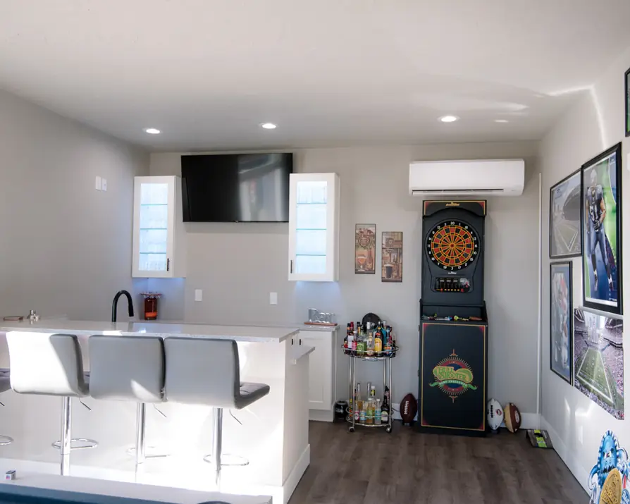 Bar wall with lit glass cabinets, under-bar lighting and a wall TV in a bonus room wired by Columbia Basin Satellite & Electric