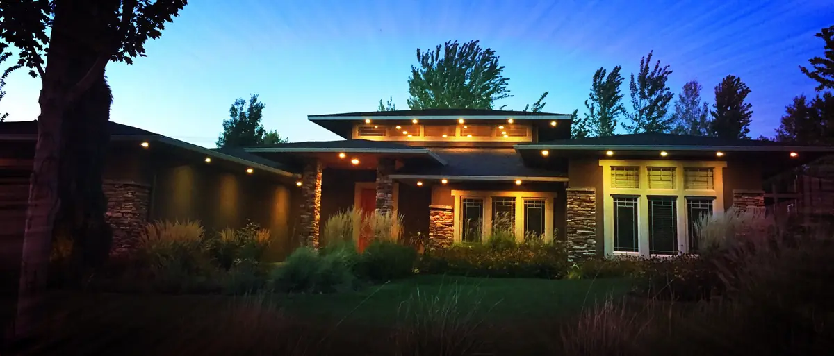 A Tri-Cities home at dusk with soffit lights and lit windows
