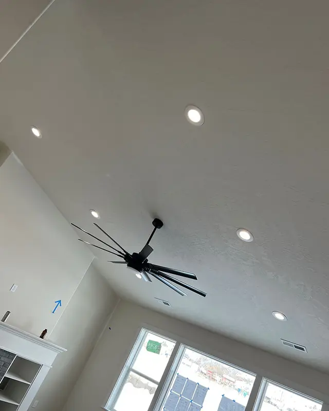 Vaulted ceiling with recessed lights and a large modern blade fan