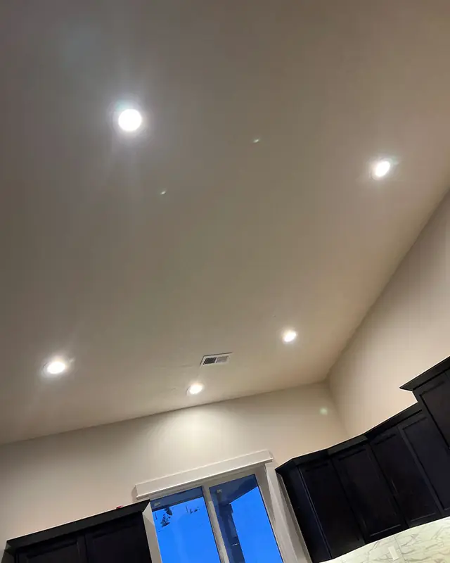 Vaulted ceiling with recessed lights over a kitchen corner